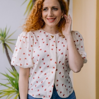 Blusa branca com corações vermelhos e botão dourado em forma de coração