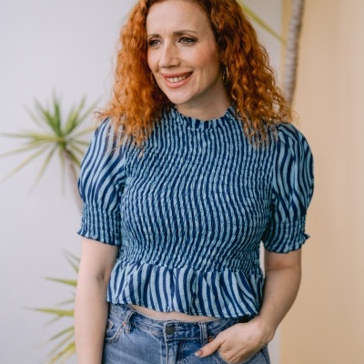 Blusa de riscas azuis franzida com manga curta e folho na barra usada com jeans