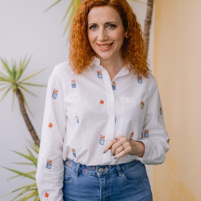 Camisa branca com bordados coloridos e calças de ganga azul