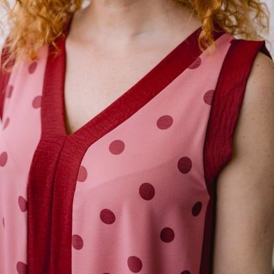 Top feminino rosa com bolinhas vermelhas e gola em V vermelha escura