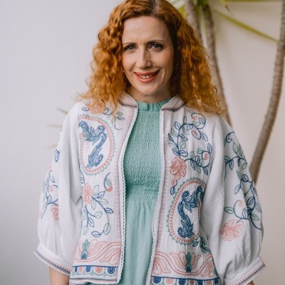 Casaco branco bordado com motivos florais e blusa verde claro.