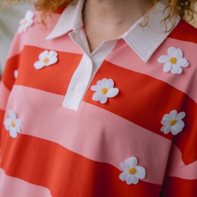 Camisola com riscas rosa e vermelho e flores brancas de plástico
