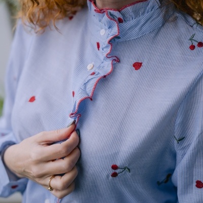Camisa azul clara com riscas finas e bordado de cerejas vermelhas com gola folhada