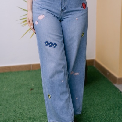 Jeans bordados com flores, corações e estrelas azuis e cor-de-rosa com botas douradas