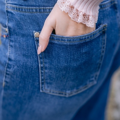 Detalhe de mão em bolso traseiro de jeans azul