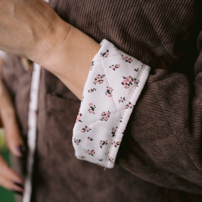 Casaco castanho de bombazina com forro floral visível nos punhos e gola