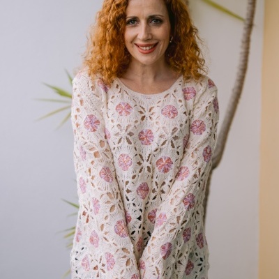 Camisola bege rendada com flores cor-de-rosa, mulher ruiva com cabelo encaracolado