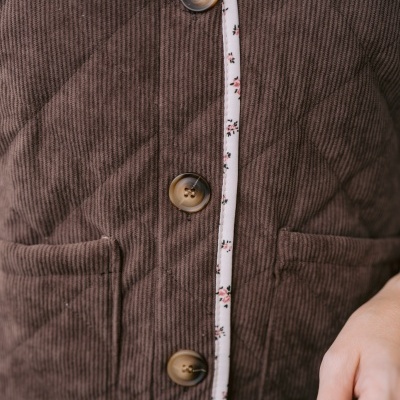 casaco acolchoado castanho com botões e rebordo branco floral