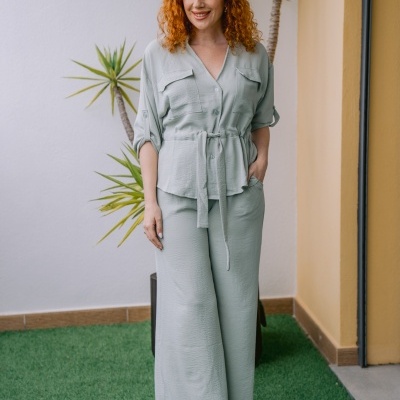 Conjunto de camisa e calças verdes claras com botas castanhas