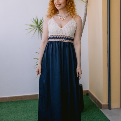 Mulher ruiva com vestido longo azul e bege com corpete em crochet e colar