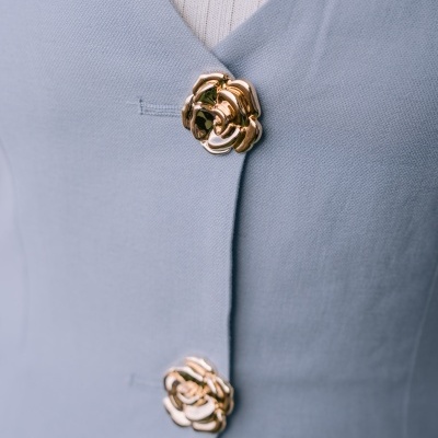 Blazer azul claro com botões dourados florais e camisola branca de malha por baixo