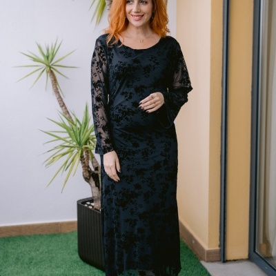 Vestido preto comprido com padrão floral e botas douradas