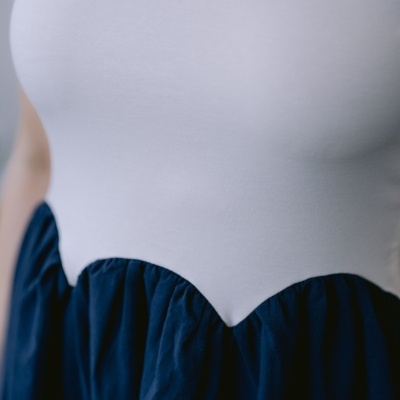 Vestido com parte superior branca e saia azul escura franzida de cintura alta.