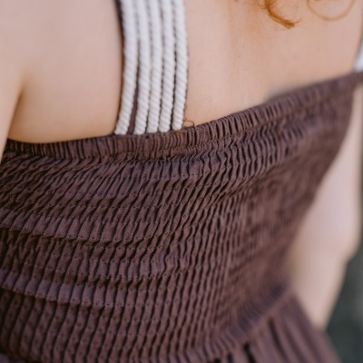 Vestido castanho com alças brancas vistos de costas