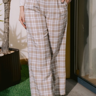 Calças xadrez branco e bege com corte largo em ambiente exterior