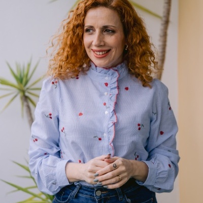 Blusa azul clara com padrão de cerejas e babados vermelhos e jeans escuros