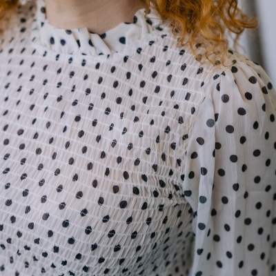 Blusa branca com bolinhas pretas e textura franzida