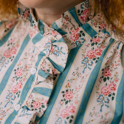 Blusa feminina com padrão floral e riscas verticais e detalhes de folhos