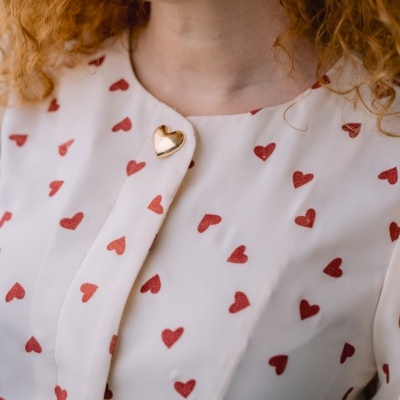 Blusa branca com coração vermelho e botão coração dourado