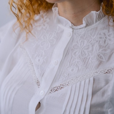 Blusa branca bordada com gola de babado e botões frontais