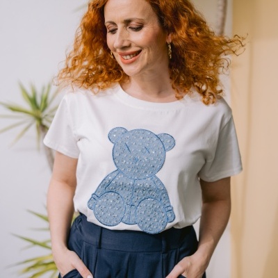 T-shirt branca com estampa de urso azul e saia azul escura