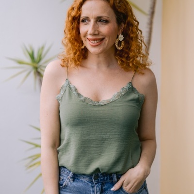 Mulher com top verde com renda e calças de ganga azuis ao ar livre