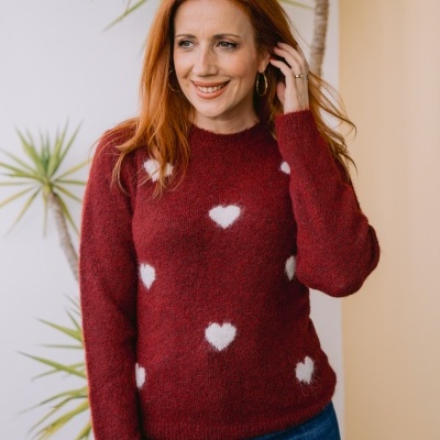 Camisola vermelha com corações brancos usada por mulher em ambiente interior