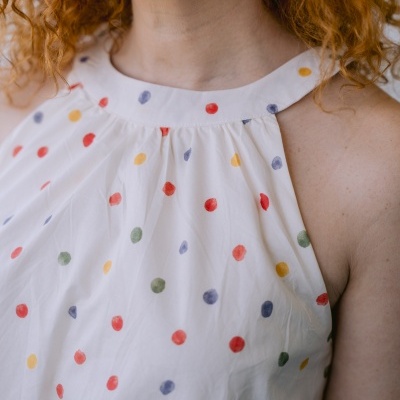 Top branco com bolinhas coloridas em vermelho, amarelo, verde e azul