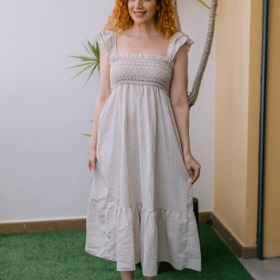 Vestido midi riscado bege e branco com detalhe franzido e sandálias douradas