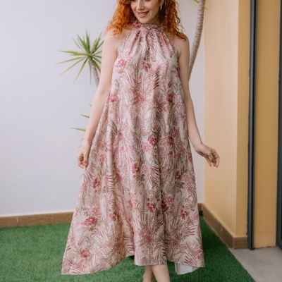 Vestido comprido com padrão floral rosa e bege e sandálias castanhas em relva artificial