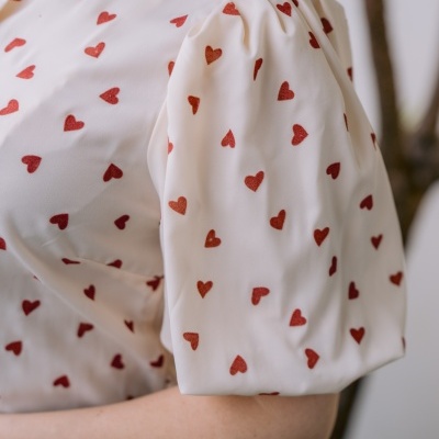 Blusa branca com corações vermelhos e mangas curtas franzidas