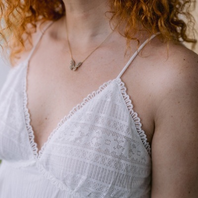 Vestido branco rendado com alças finas e colar de borboleta