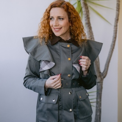 Mulher com casaco verde militar com botões dourados e cinto na cintura