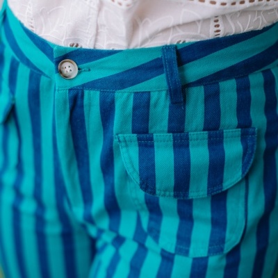 Calças com riscas azul e verde e camisa branca com padrão floral