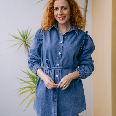 Vestido curto em ganga azul com botões e cinto, mulher ruiva em ambiente exterior