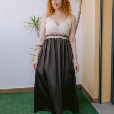 Vestido comprido com parte superior em malha branca e castanha e parte inferior castanha escura numa mulher ruiva, em ambiente exterior