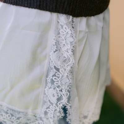 Camisola preta com bolinhas brancas e saia branca com detalhe de renda