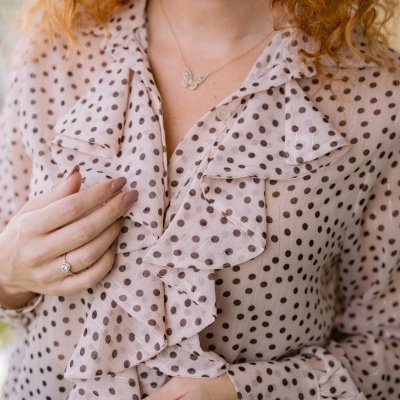 Blusa rosa com bolinhas castanhas e folhos na parte frontal