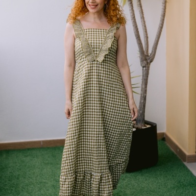 Vestido midi padrão vichy verde e branco com folhos, mulher ruiva, planta ao fundo