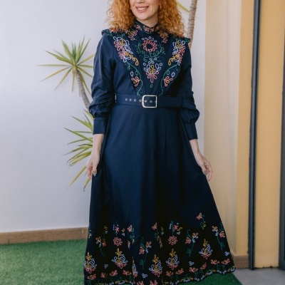 Vestido comprido azul escuro com bordados florais coloridos e cinto largo