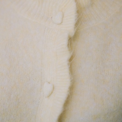 Cárdigan amarelo claro com botões revestidos e gola ondulada