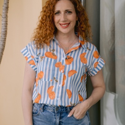 Blusa feminina azul e branca com estampa de laranjas e calças de ganga