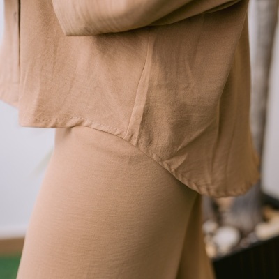 Roupa bege claro de tecido leve com camisa e calças justas