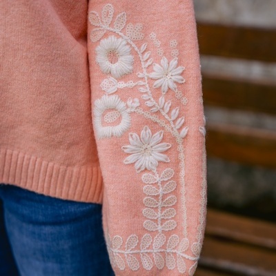 Manga de camisola rosa com bordado branco em forma de flores e folhas