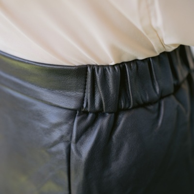 Cintura com calças pretas de couro e camisa branca