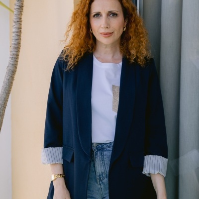 Pessoa com blazer azul escuro, t-shirt branca e jeans azul claro