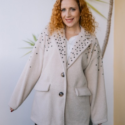 Casaco bege claro feminino com bolinhas pretas decorativas nos ombros
