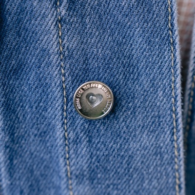 Botão prateado com coração em tecido jeans azul