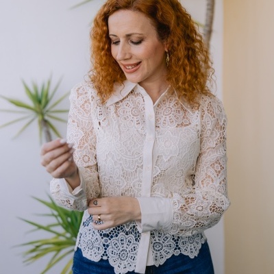 Camisa branca de renda com padrão floral e calças de ganga azuis