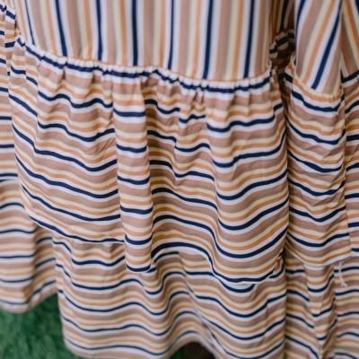 Vestido às riscas com folhos e tecido leve em tons castanho claro e azul